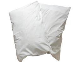 dos almohadas blancas con estuches después del uso de los huéspedes en el hotel o en la habitación del resort aisladas en fondo blanco con camino de recorte, concepto de sueño cómodo y feliz en la vida diaria