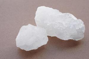 Crystal clear alum stones or Potassium alum isolated on brown background.  Useful for beauty and spa treatment. Use to treat body odor under the armpits as deodorant and make water clear. photo