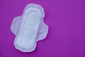 White sanitary pad  on pink background. Concept, female's hygienic product for period's day. Protect from menstruation blood to stain underwear clothes. Woman healthcare. Intimate hygiene. Top view. photo