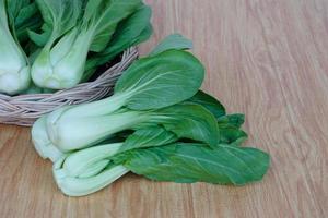 bok choy fresco o pak choi o repollo chino sobre fondo de madera y en una cesta para cocinar. concepto, vegetales orgánicos. comida sana. altas fibras y vitaminas. foto