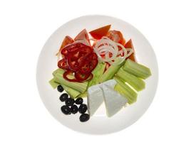 Traditional Greek salad. Tomatoes, sliced cucumbers, paprika, onion, black olives, cheese in ceramic plate, isolated on white background. Top view photo