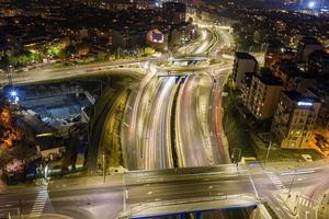 hermosa carretera de cruce de tráfico nocturno con luces de movimiento de vehículos vista aérea desde drones foto