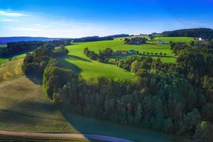 increíble paisaje primaveral con verdes colinas y granjas en el corazón de Alemania, antes del atardecer foto