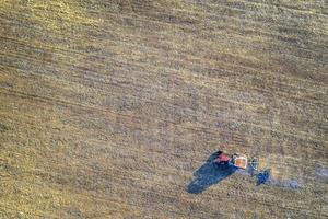 Aerial view from drone of field processing with the tractor. Agriculture processing of fields. Top view photo