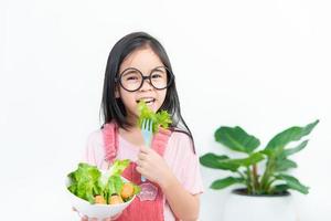 niños niña asia comiendo verduras foto