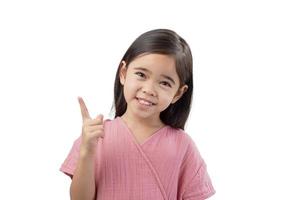 retrato de una linda chica asiática con el pelo largo gesticulando con el dedo acusador mientras está de pie contra el fondo blanco foto