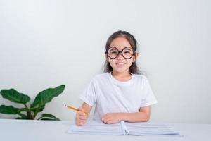 Portrait of little pupil writing at desk in  Student girl study doing test in primary school. Children writing notes in classroom. Education knowledge concept photo
