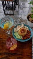 Nasi Goreng Jawa. The popular Indonesian rice dish of fried rice. cooked Javanese style with sweet soy sauce. Accompanied crackers, sausage, cucumber pieces, and soft drink. photo