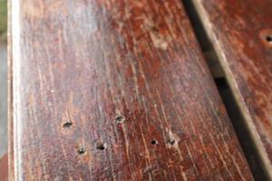 Wooden plank material brown coat varnished with some holes from nails. photo