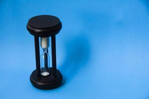 Minute glass isolated on light blue background. Copy space concept photo