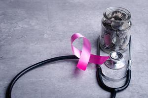 medalla con estetoscopio de cinta rosa. concepto de finanzas con atención médica. foto