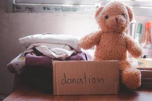 ropa, libros, ositos de peluche para donaciones. concepto de donación social. foto