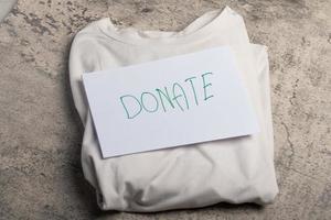 White shirt laying on the floor accepting clothing donations, top view photo