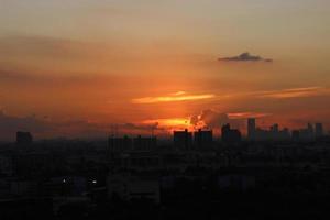 dark storm cloudy sky in rainy day on sunset time with city building background photo