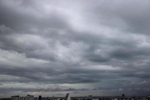 cielo nublado de tormenta oscura en un día lluvioso con fondo de construcción de la ciudad foto