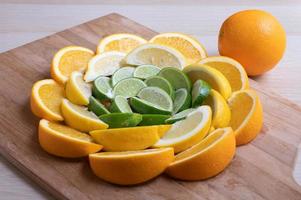 Citrus wedges arranged in a circle with a whole orange sitting on the side.