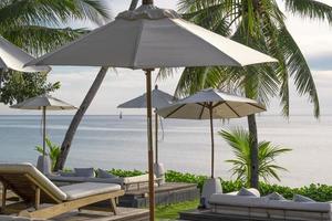 relaxing sun bed laying warm weather in summer vacation at sea beach hua hin Thailand. big umbrella white color protect uv from sun light.