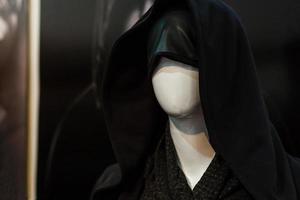 a dummy woman in a black hood is in the store photo