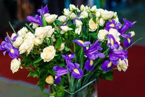 hermoso ramo de novia de lirios azules y rosas blancas en un jarrón foto