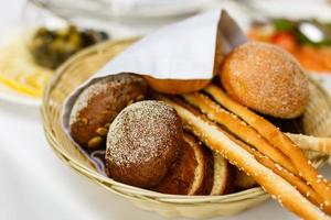 Bread in basket with butter under sunlight Buns bread in a basket table photo