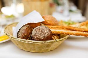 Bread in basket with butter under sunlight Buns bread in a basket table photo