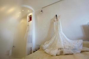 Beautiful wedding dress on hanger in room photo