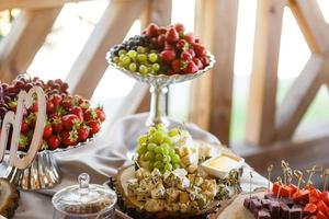 decoración de frutas de mesa de boda en el restaurante, piña, fresa, uva foto