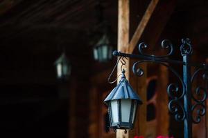 viejo farol oxidado en una casa de madera y flores foto