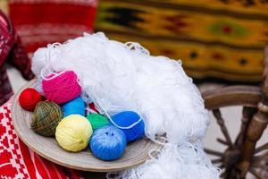 Colorful yarn for knitting in green basket on wooden table on window background Crochet for knitting photo