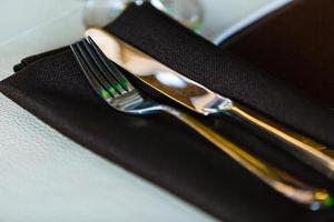 Vintage silverware with a twig of rosemary and empty tag on rustic wooden background Serving in the restaurant fork and knife photo