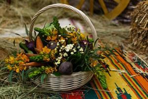 Basket with organic vegetables on the green grass and flowers. Outdoors. freshly harvested vegetables. raw vegetables in wicker basket.basket with Vegetables and Flowers photo