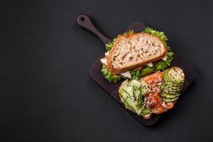 Fresh tasty sandwich with salmon, avocado and sesame and flax seeds photo