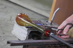 The master works with glass at a glass factory. photo