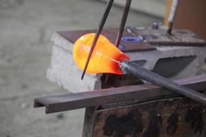 The master works with glass at a glass factory. photo