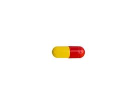 droga. cápsula, tableta de color rojo y amarillo aislada en un fondo blanco. medicina, farmacéutica foto