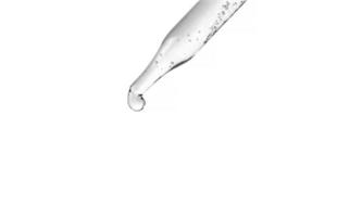 Cosmetic pipette with drops of cosmetic oil close-up on a white background. Liquid transparent gel, serum, emulsion photo