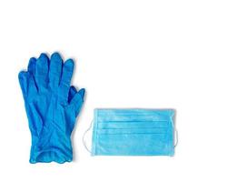 protección de virus. guantes de goma azules y una máscara médica sobre un fondo blanco. foto