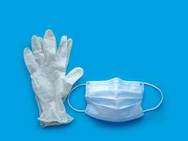 Rubber gloves and medical mask on blue background. The ncov-19 coronavirus pandemic. Anti-virus protection against flu. photo