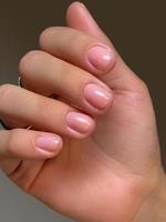 Manicure in nude style. Women's hands with beautiful natural pink French manicure. Close-up, selective focus. Spa, skin care, beauty treatments, beauty salon photo