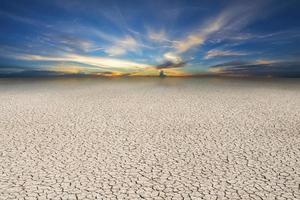 Landscape cracked soil, earth desert terrain with sunset sky photo