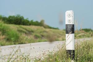 The guide post is right on the road warns car users to use the road. Perseverance concept photo