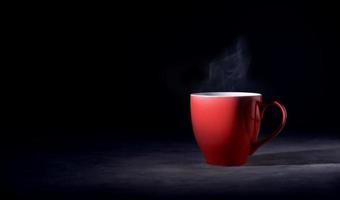 Hot Red Coffee Cup on Table with Stream. Dark Tone, Side View with more Copy Space photo