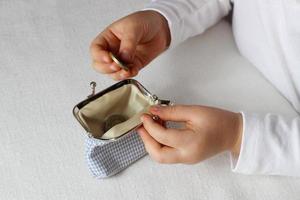 Kids hands put coins in a wallet,toddler girl with money and pusre in hand.Learning financial responsibility and planning savings.Financial education for child,financial support.Investing in children photo