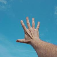 mano arriba en el aire, gesticulando en el cielo sintiéndose libre foto