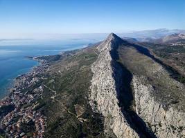 Aerial drone view of the seacoast city in Croatia. Mountain above the city. Adriatic sea and dalmatia area. Travel and holidays destination. photo