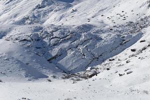 vista asombrosa de la montaña llena de nieve en invierno durante un día soleado. hermosa cadena montañosa y una increíble atracción para los escaladores alpinos. estilo de vida aventurero. foto