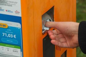 A woman's hand buys a ticket in a ticket machine. photo