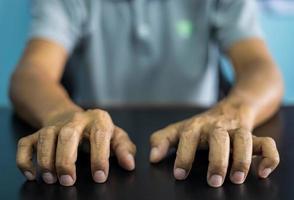 Close-up front view of both hands of a thai man wearing gray shirt making various gestures. photo