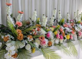 Close-up view of rows of white bouquets, roses and chrysanthemums of various colors. photo
