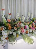 Close-up view of rows of white bouquets, roses and chrysanthemums of various colors. photo